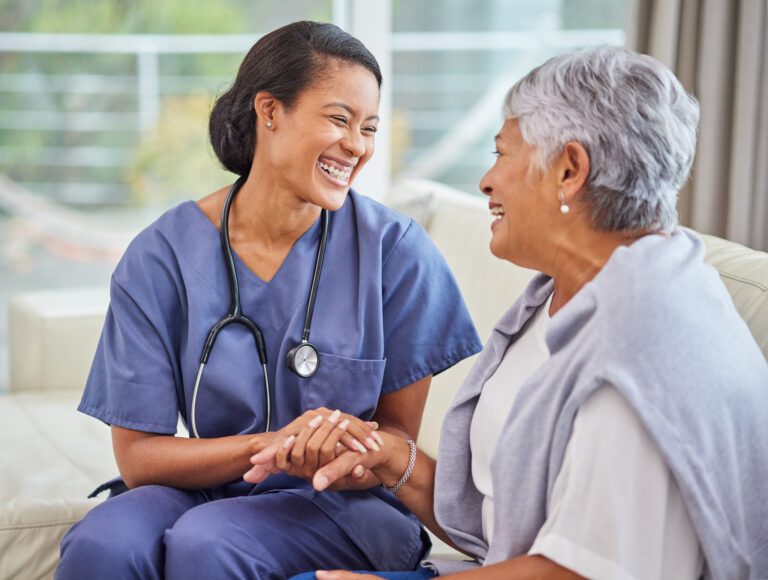 An old lady talking and smiling with a doctor